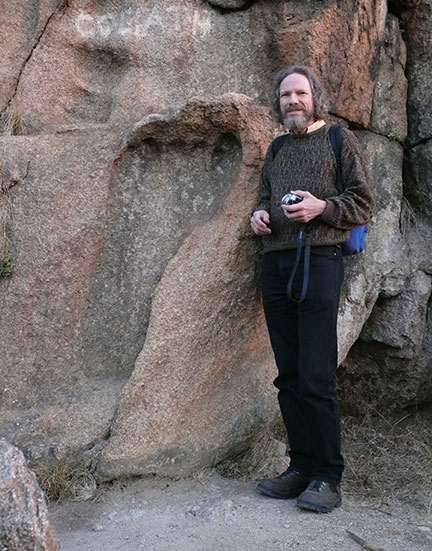 Image of Robert Schoch standing by the so-called giant's footprint in South Africa